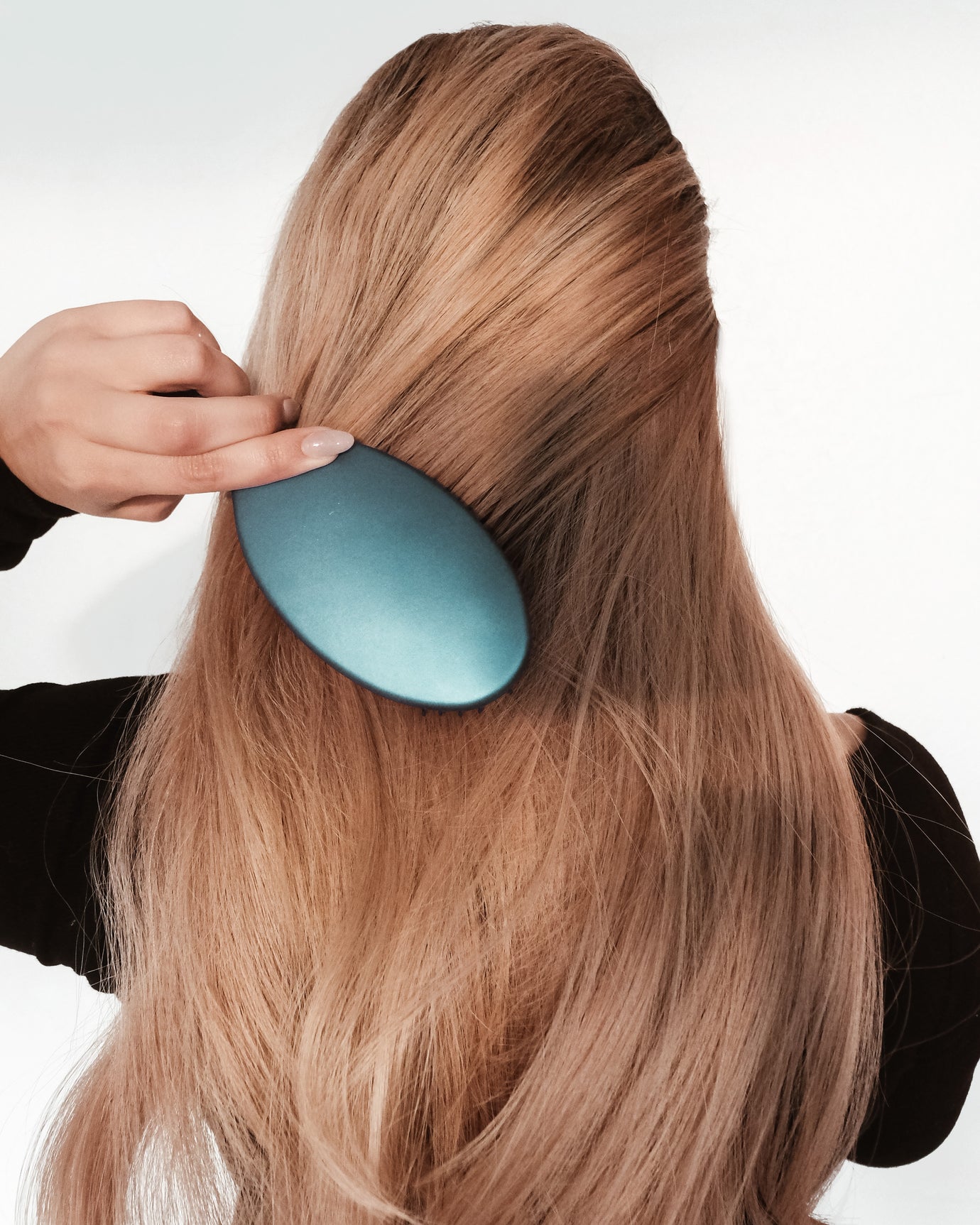 A woman brushing her Hairlaya hand-tied extensions.